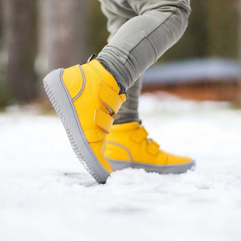 Ett barn står på snö i ett par Penguin från Be Lenka.