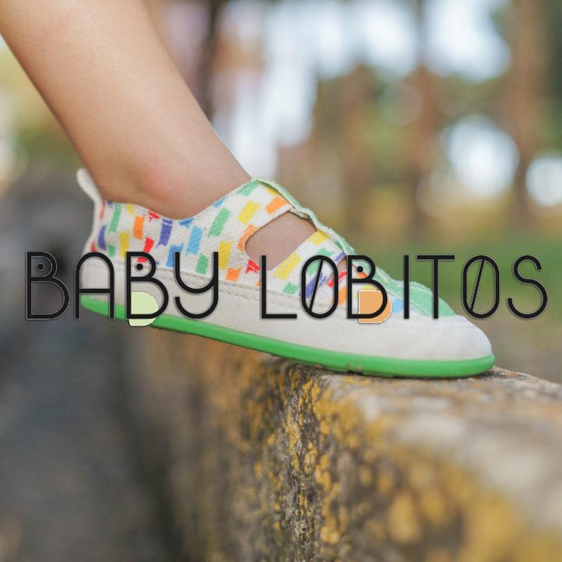 En barnfot med barfotasandal på sig från varumärket Baby Lobitos.