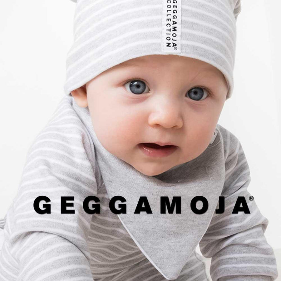 Ett litet barn kryper och är klädd i söta gråa babykläder från märket Geggamoja.