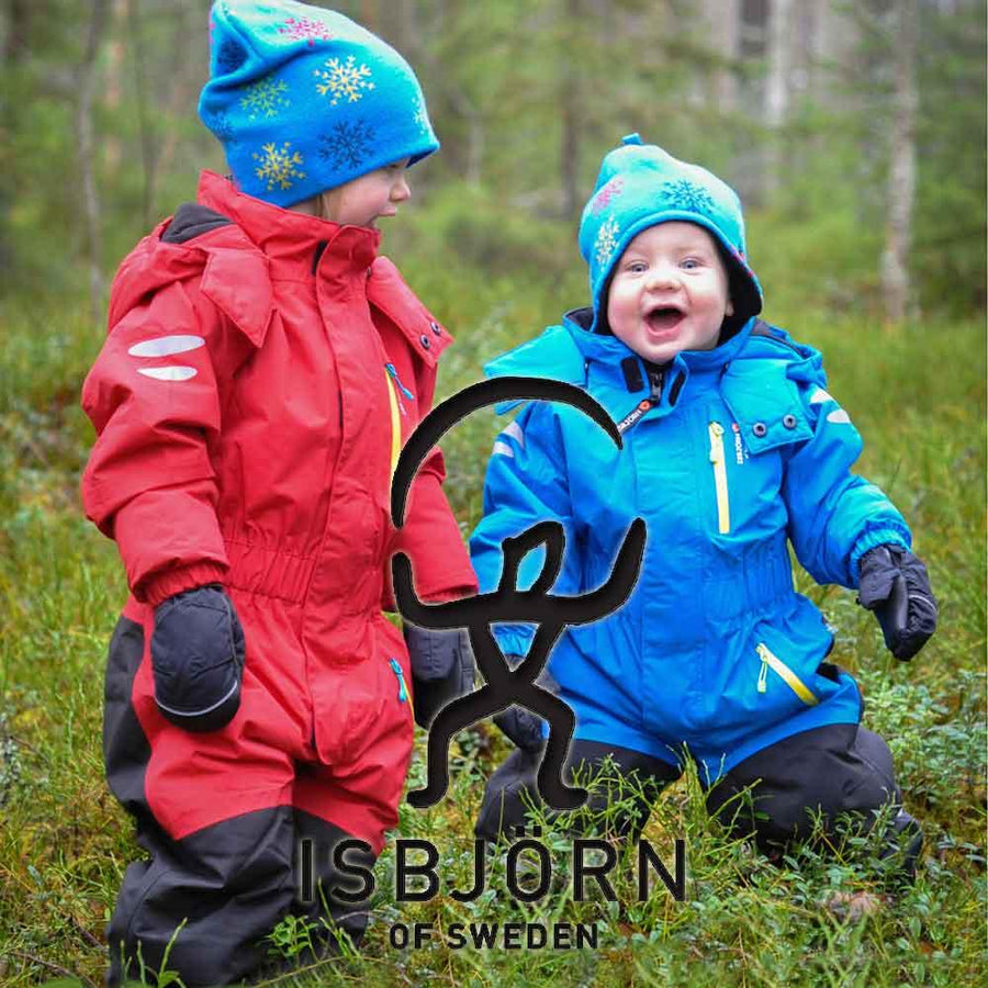 Två glada barn står i skogen och leker i overaller från det svenska märket Isbjörn of Sweden.