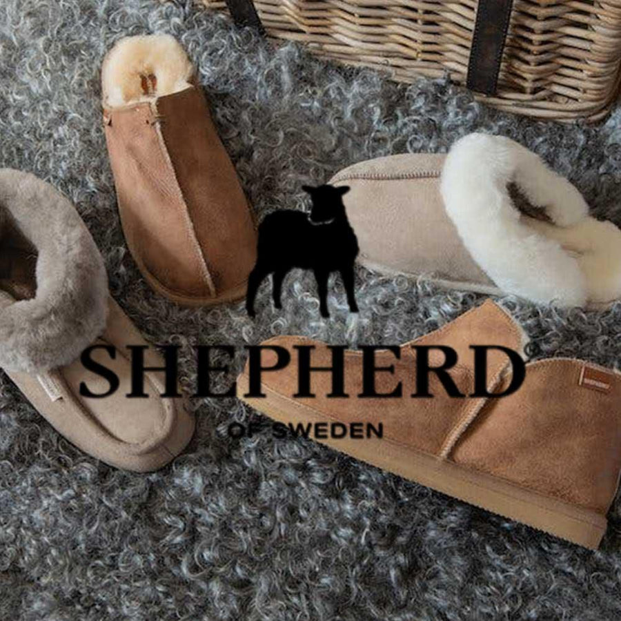 Massor av barntofflor från det svenska märket Shepherd i fårskinn ligger på en fårull.